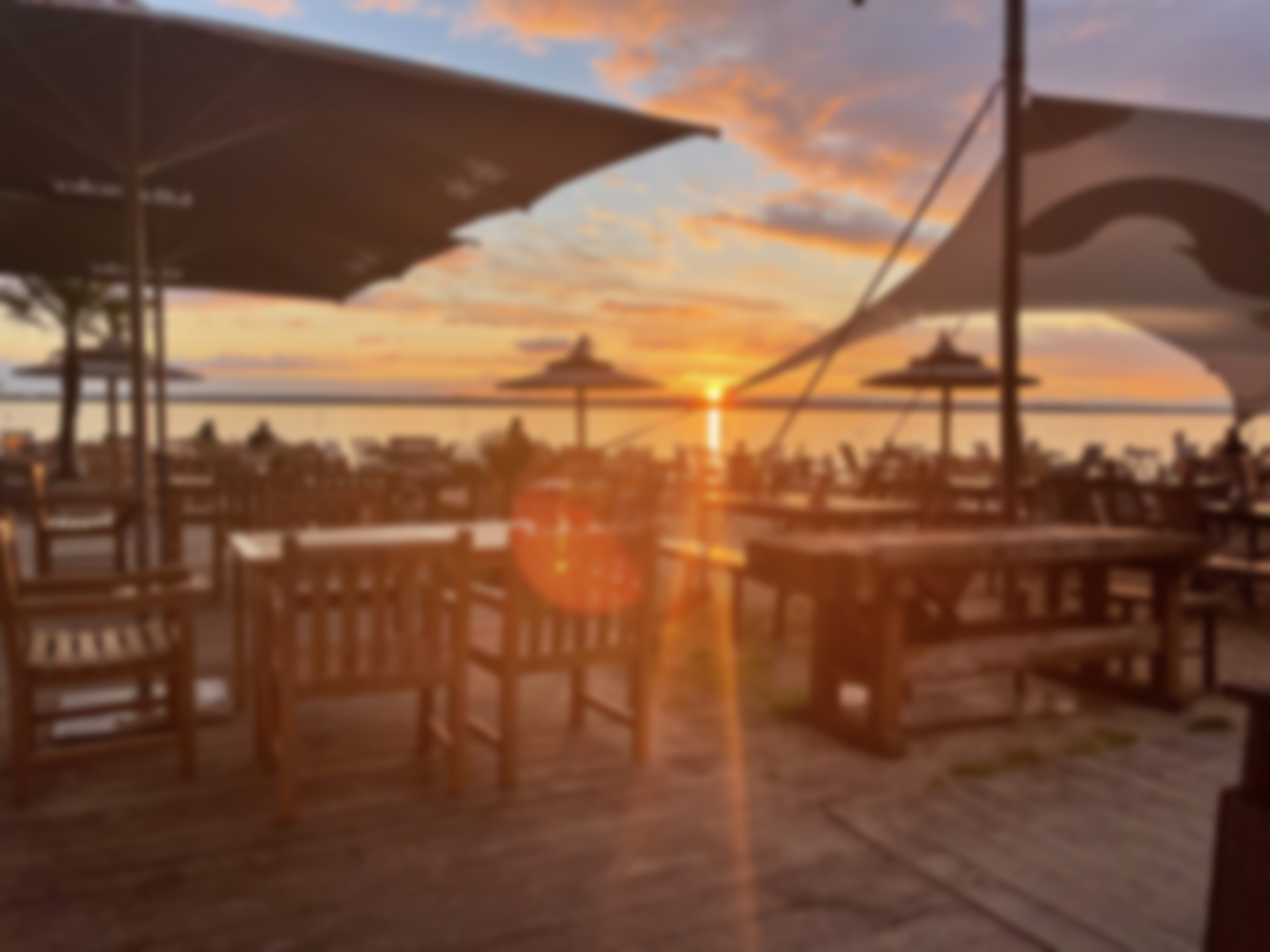 Sitzplätze der Bar dü Mar direkt am Dümmersee im Sonnenuntergang